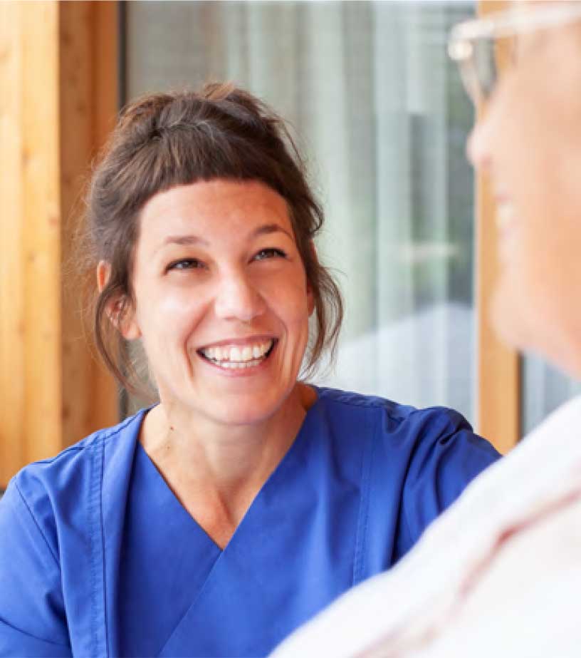 Pflegekraft im Gespräch mit einer Patientin